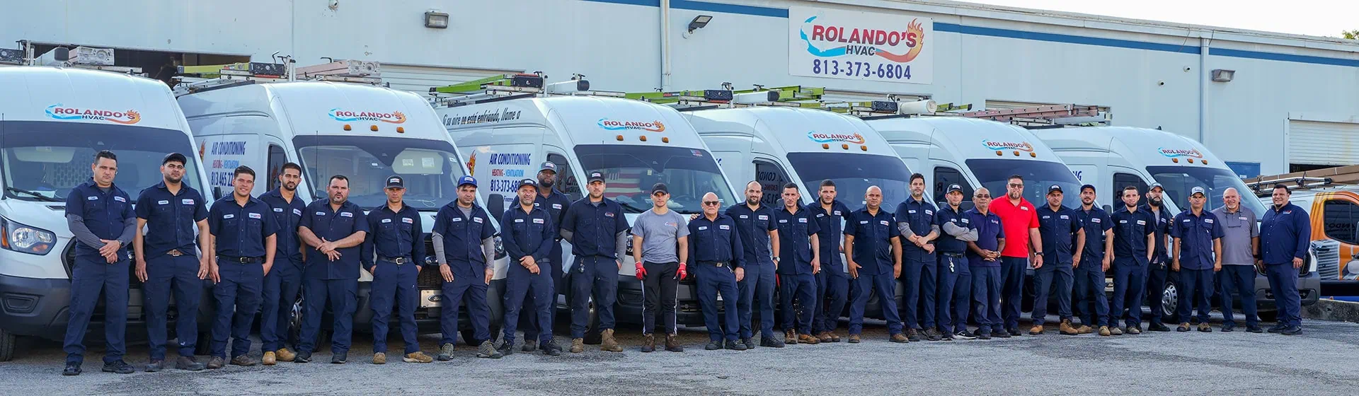 Rolando's HVAC team standing in front of service vehicles