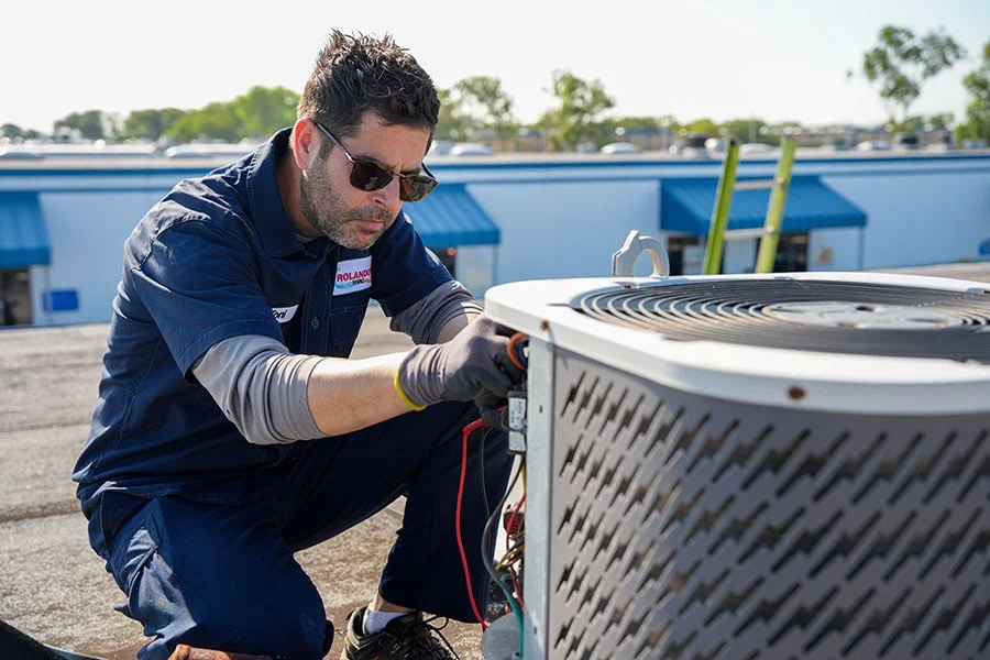Rolando's HVAC technician servicing an outdoor air conditioner