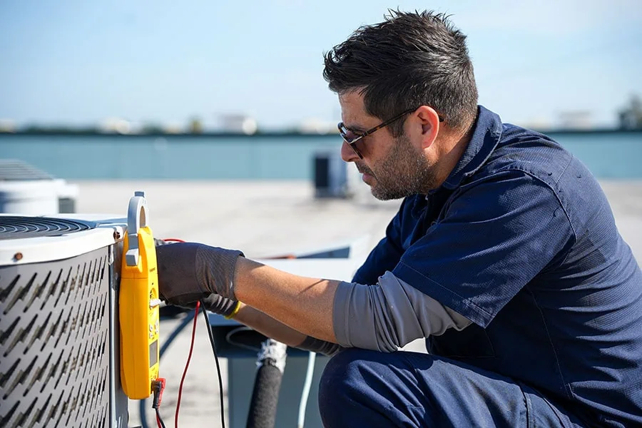 HVAC technician servicing an outdoor air-conditioning unit